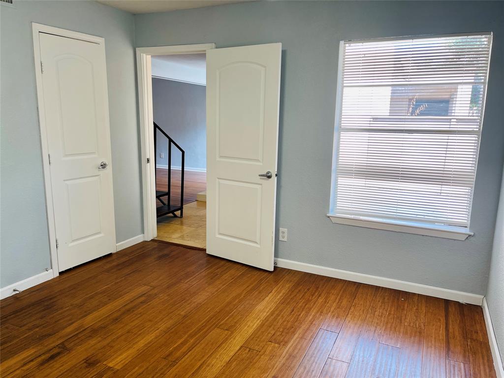 3121 Park Lane, Unit 1105 Dallas, TX 75220 - Photo 9 of 19 Unfurnished bedroom with dark wood-type flooring and multiple windows