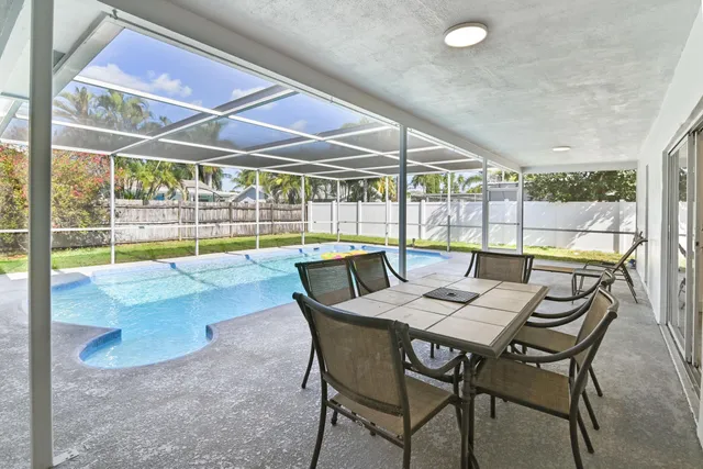 a dining room with furniture and a floor to ceiling window