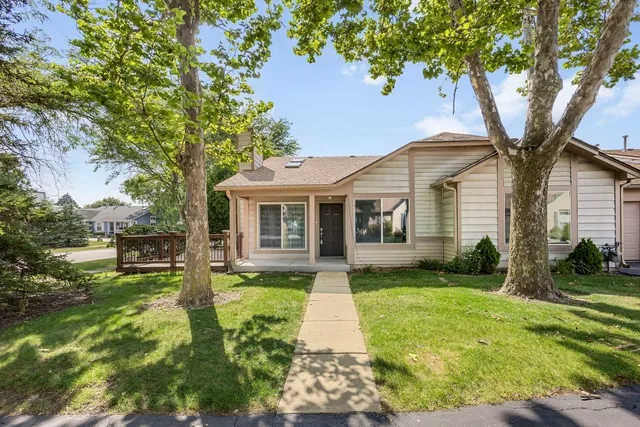 a front view of a house with yard and green space