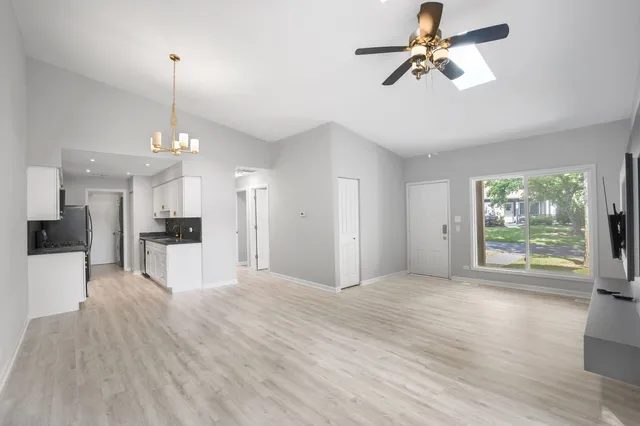 a view of a kitchen with wooden floor and a ceiling fan