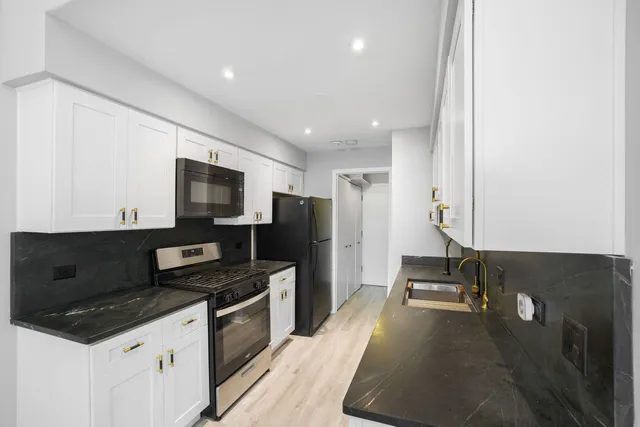 a kitchen with a refrigerator and a stove top open