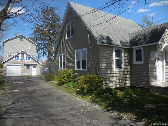 a front view of a house with a garden and plants