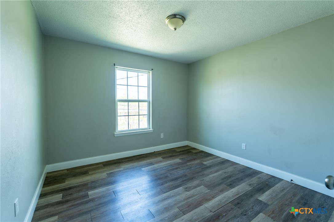 512 Sunset Lane, Unit AD Copperas Cove, TX 76522 - Photo 8 of 23 an empty room with wooden floor and windows