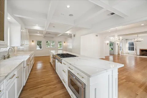 a large white kitchen with a stove and sink