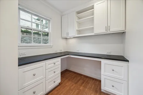 a kitchen with granite countertop white cabinets and a window