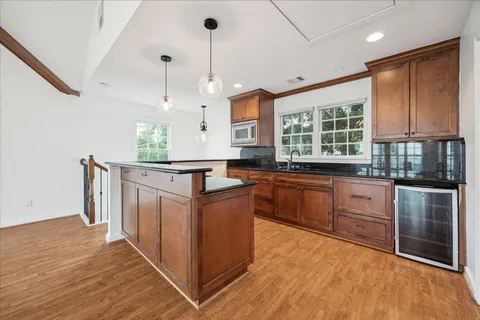 a kitchen with stainless steel appliances granite countertop a stove a sink dishwasher and a refrigerator with wooden floor