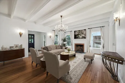 a living room with furniture a fireplace and a chandelier