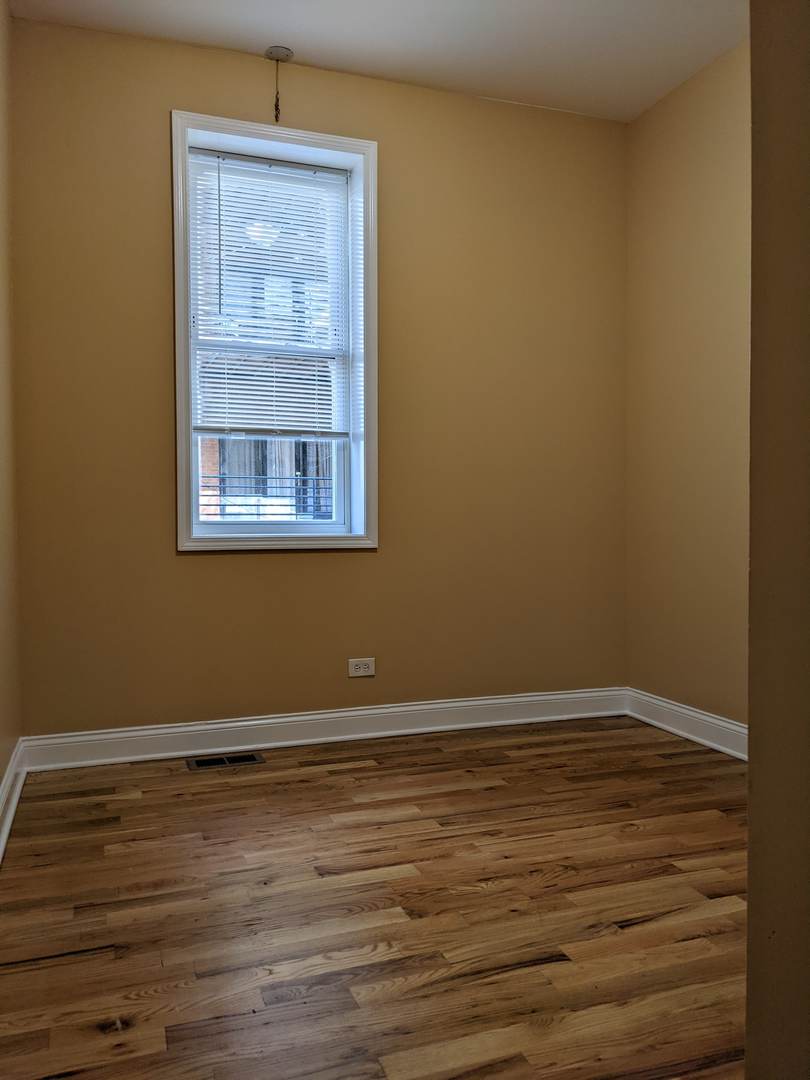 712 South Aberdeen Street, Unit 1A Chicago, IL 60607 - Photo 23 of 28 a view of an empty room with wooden floor and a window