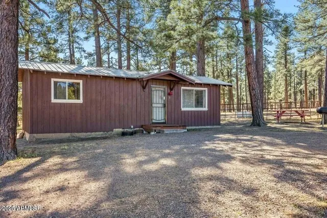 a view of a house with a yard and large tree