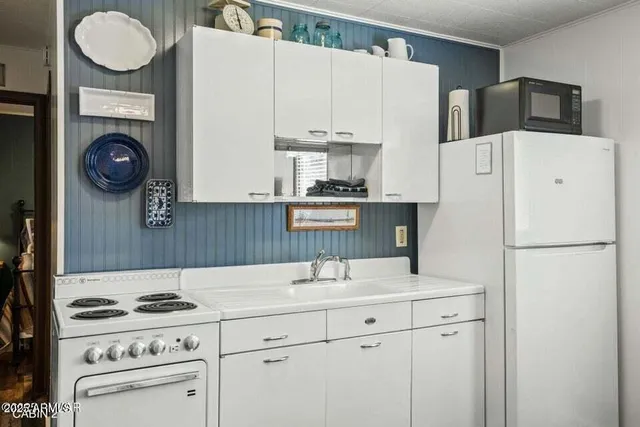 a kitchen with a white stove top oven and refrigerator