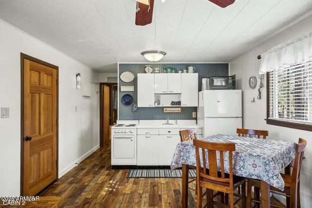 a kitchen with a table chairs refrigerator and microwave