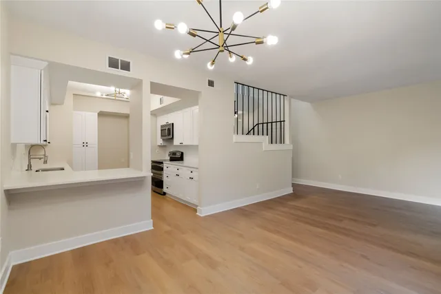 a view of a big room with chandelier fan and windows