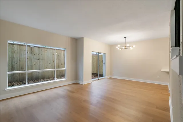 an empty room with wooden floor and window
