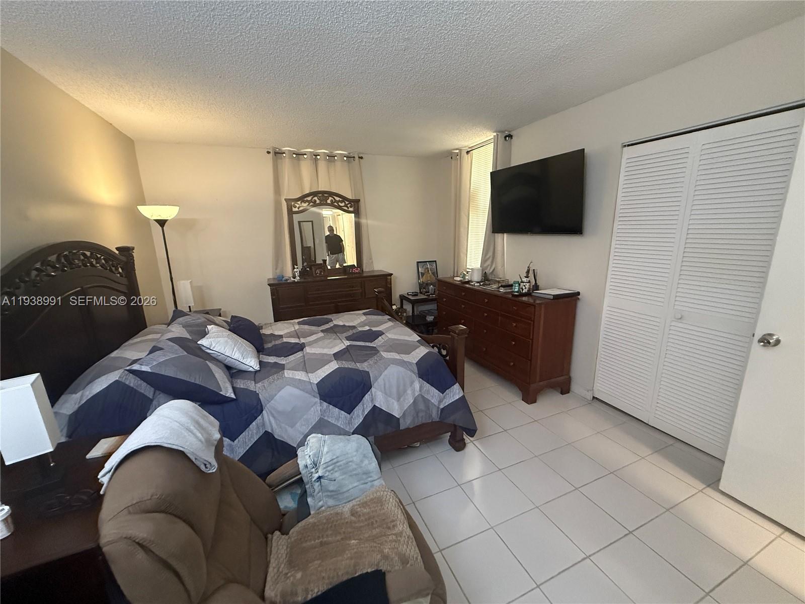 12209 Southwest 14th Lane, Unit 1101 Miami, FL 33184 - Photo 13 of 18 a bedroom with a bed and television