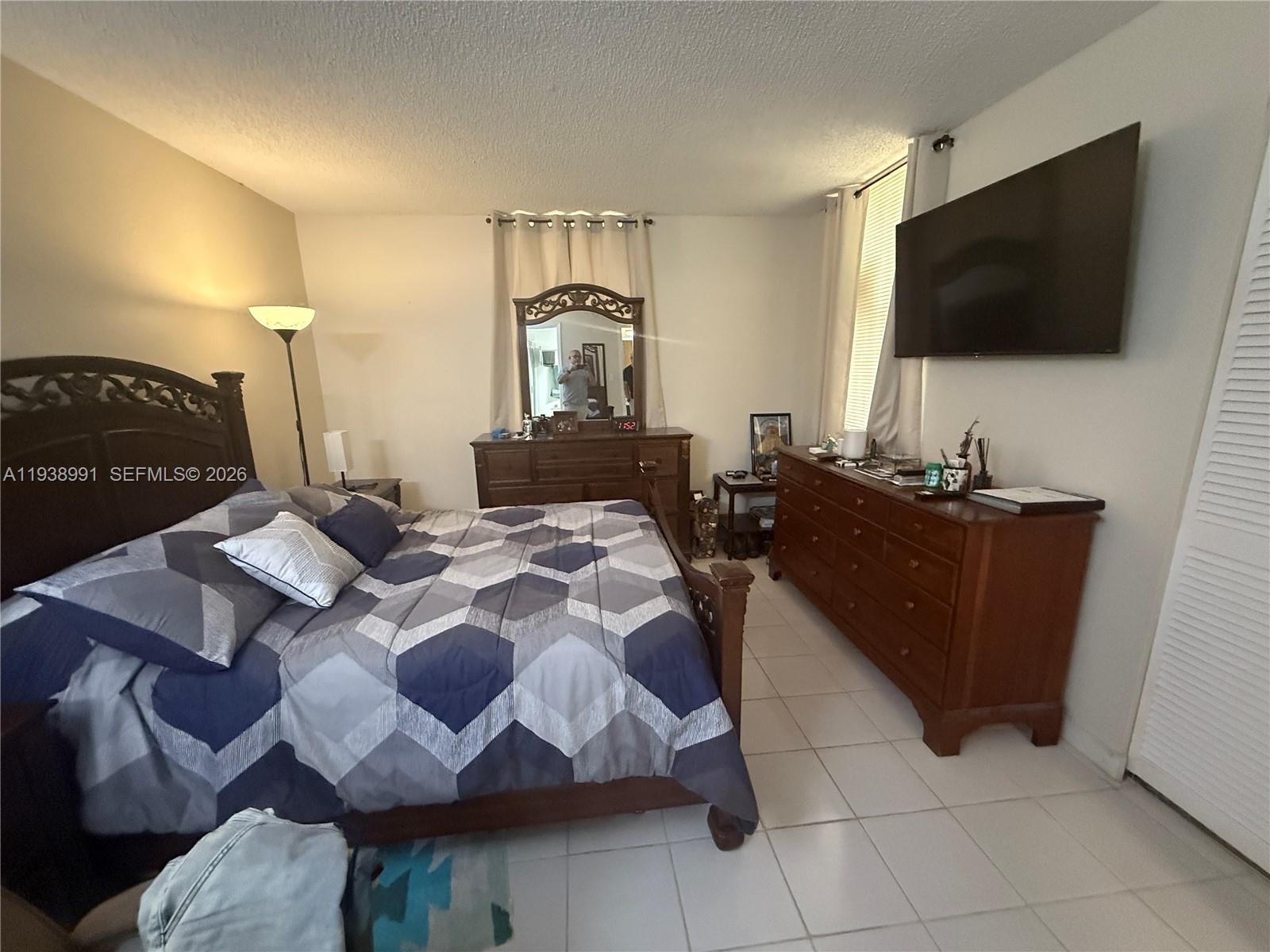 12209 Southwest 14th Lane, Unit 1101 Miami, FL 33184 - Photo 14 of 18 a bedroom with a bed and a flat screen tv