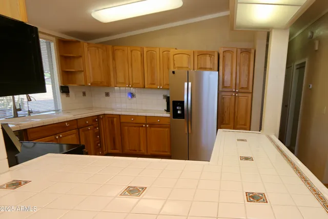 a kitchen with a refrigerator sink and cabinets