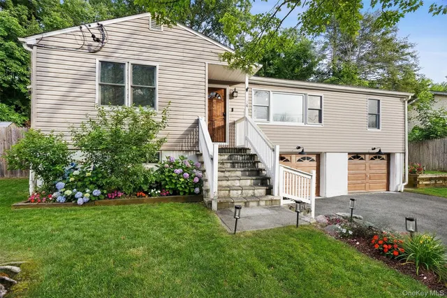 a front view of house with garden and trees