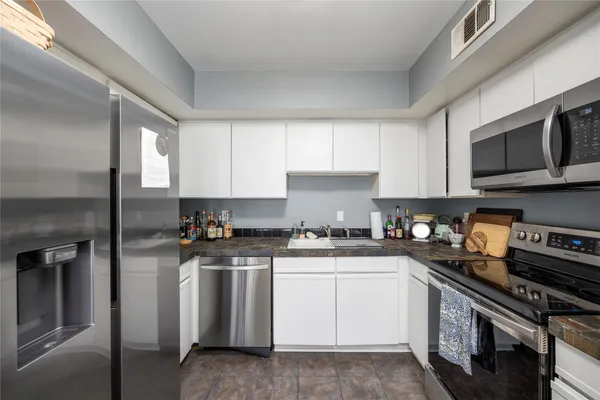 a kitchen with stainless steel appliances granite countertop a stove a sink dishwasher and a refrigerator