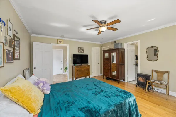 a spacious bedroom with a bed and a flat screen tv