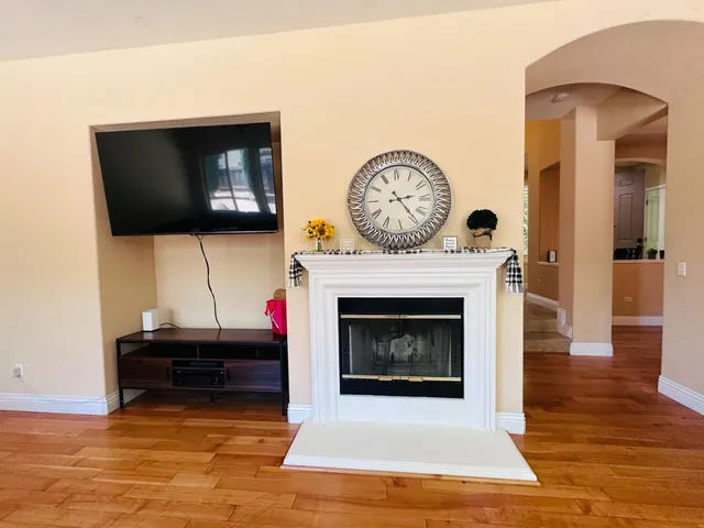a living room with furniture a flat screen tv and a fireplace