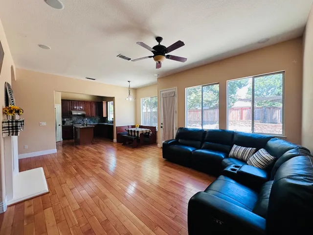 a living room with furniture and a flat screen tv with wooden floor