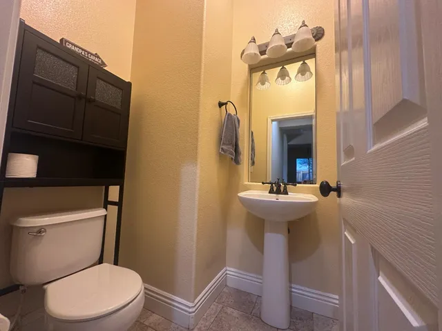 a bathroom with a sink a toilet and mirror