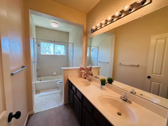 a bathroom with a double vanity sink a mirror and a bathtub