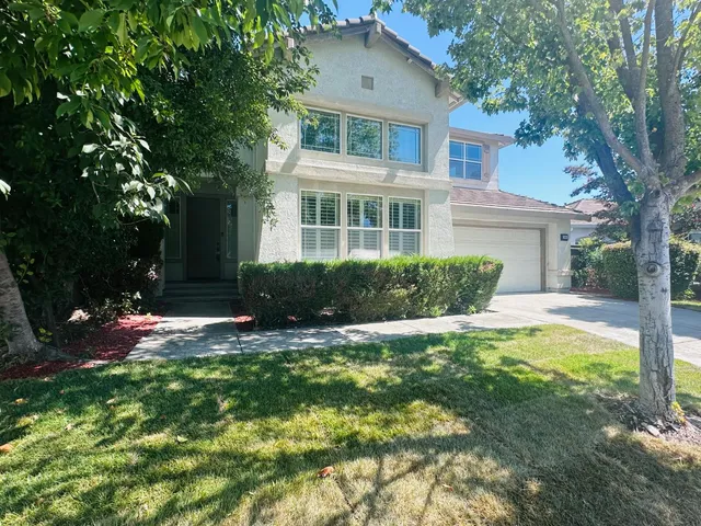 a front view of house with yard and green space