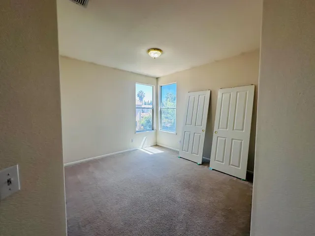 an empty room with windows and closet