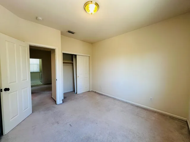 an empty room with closet and mirror