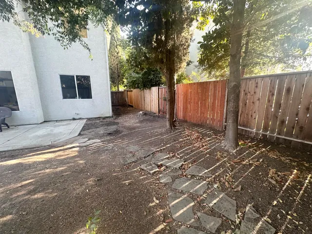 a view of a house with backyard and trees