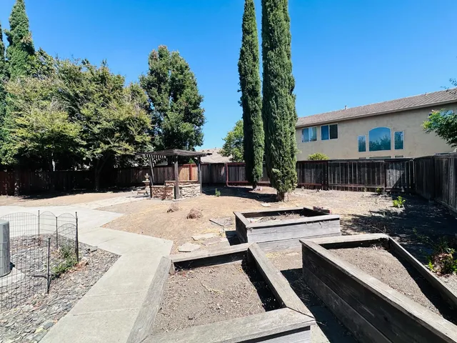 a view of a house with backyard and sitting area
