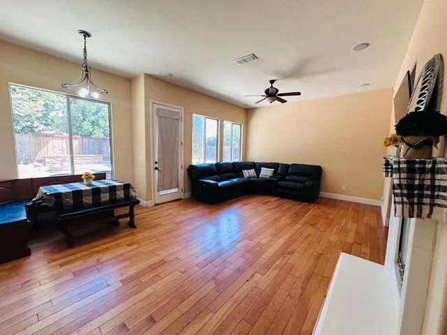 a living room with furniture and a wooden floor