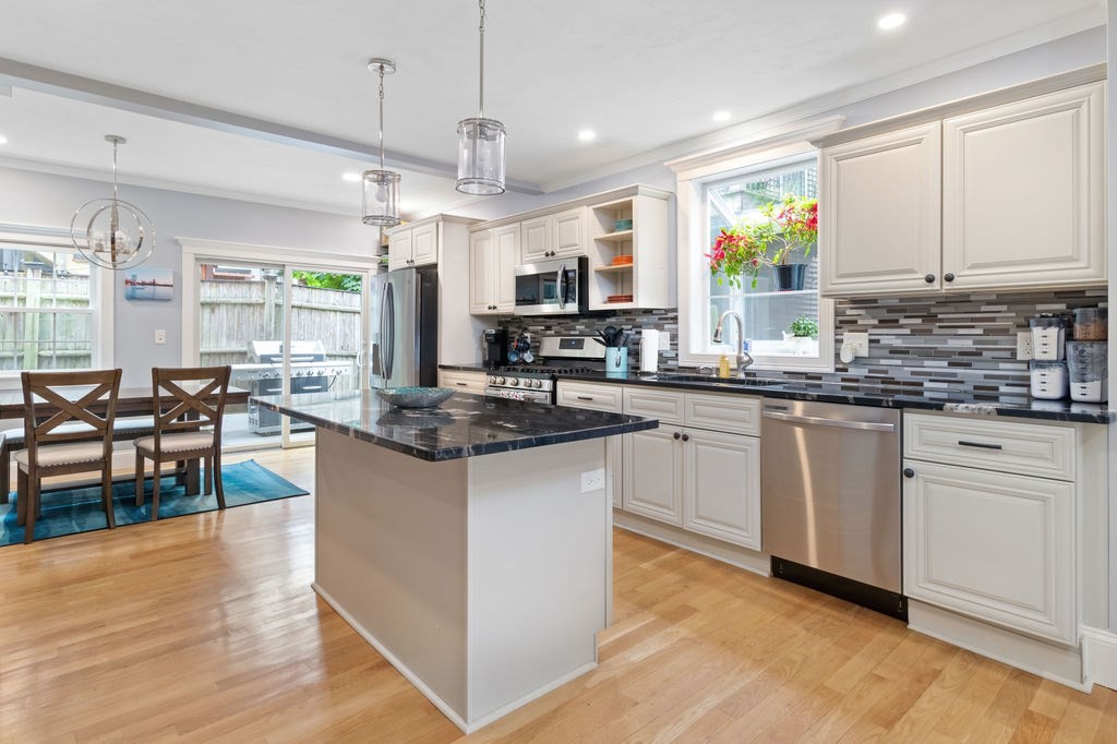 4 Goodwin Court Boston, MA 02127 - Photo 7 of 27 a kitchen with stainless steel appliances granite countertop wooden cabinets a stove a sink a dining table and chairs