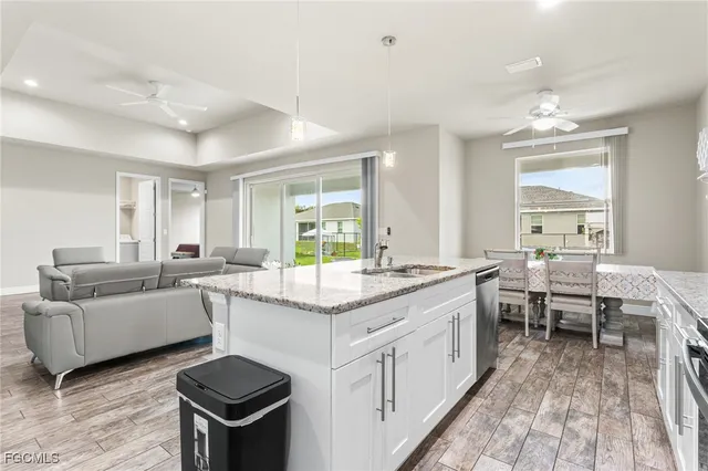 a large white kitchen with a window and stainless steel appliances
