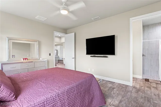 a bedroom with a bed a flat tv screen and a chandelier