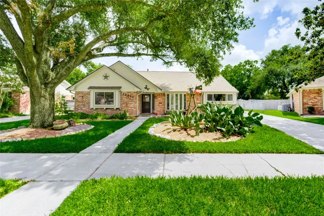 a front view of a house with a yard and potted plants