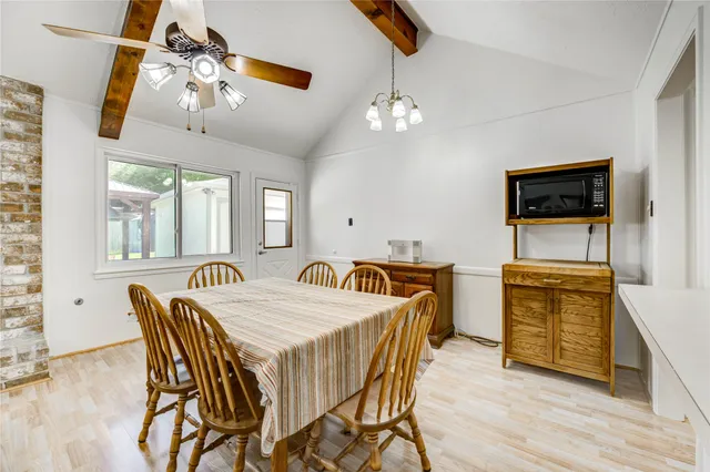 a dining room with furniture a chandelier and wooden floor