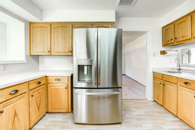 a kitchen with stainless steel appliances granite countertop a refrigerator a stove and a sink with cabinets