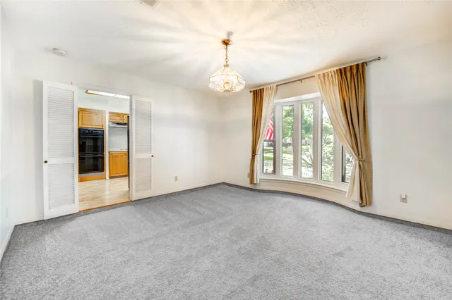 an empty room with windows and chandelier
