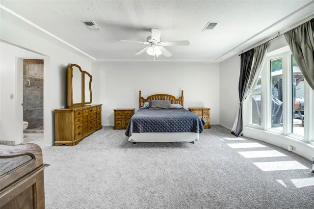 a spacious bedroom with a bed and a chandelier