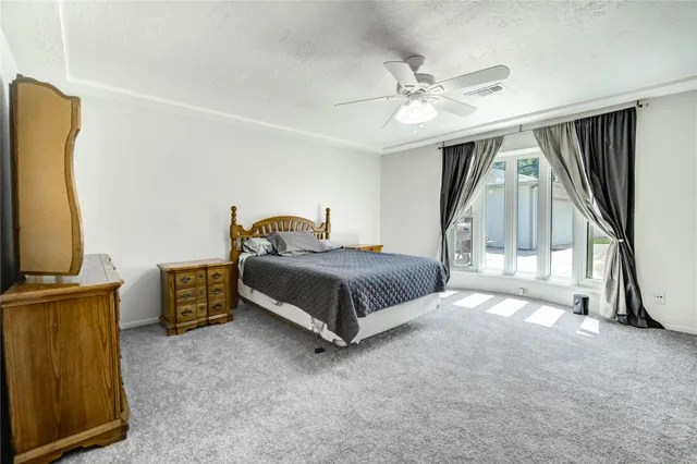 a bedroom with a bed a flat screen tv and a dresser