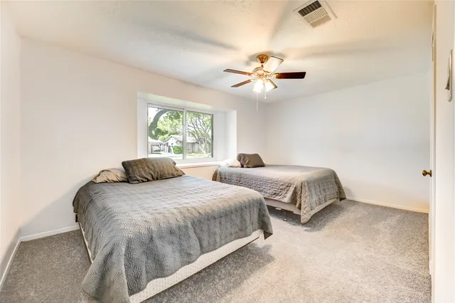 a bedroom with double bed and a ceiling fan