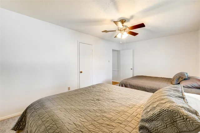 a bedroom with a bed and a ceiling fan