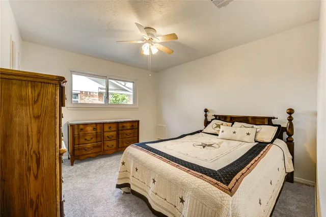 a bed sitting in a bedroom next to a window and a chandelier