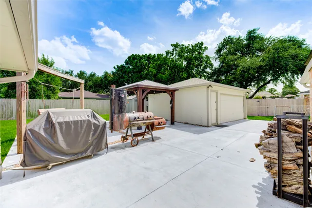 a patio with a table and chairs and potted plants