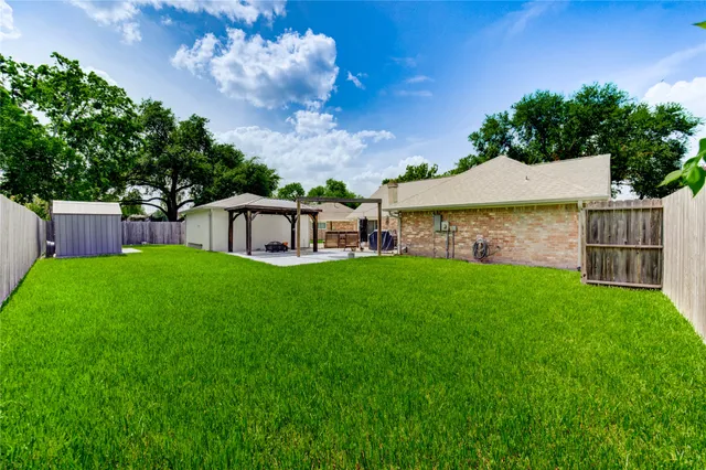 a view of a house with a yard potted plants and large tree