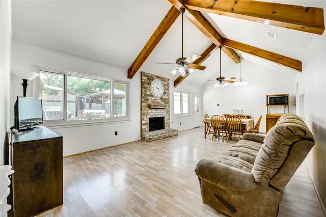 a living room with furniture a fireplace and wooden floor