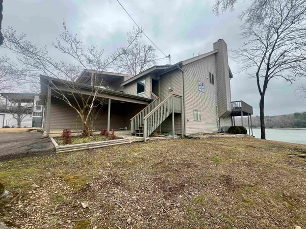 a kitchen with stainless steel appliances granite countertop a kitchen island a stove a sink dishwasher a refrigerator and cabinets with wooden floor