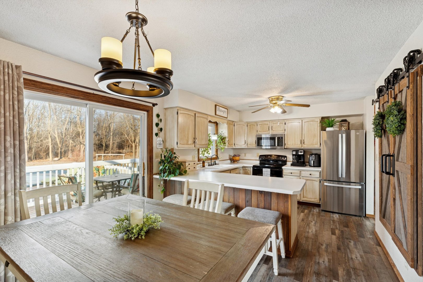 5430 Holly Road Fulton, IL 61252 - Photo 13 of 33 a kitchen with stainless steel appliances a dining table chairs stove and refrigerator